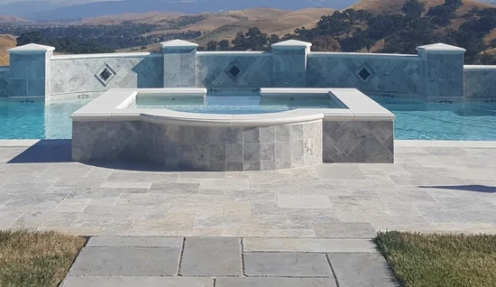 Custom pool construction with raised stone spa in Danville by Aqua Dream Pools