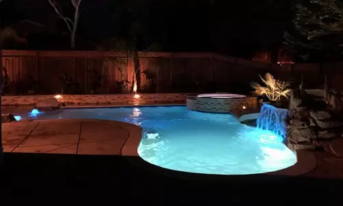 Night view of custom pool and tub